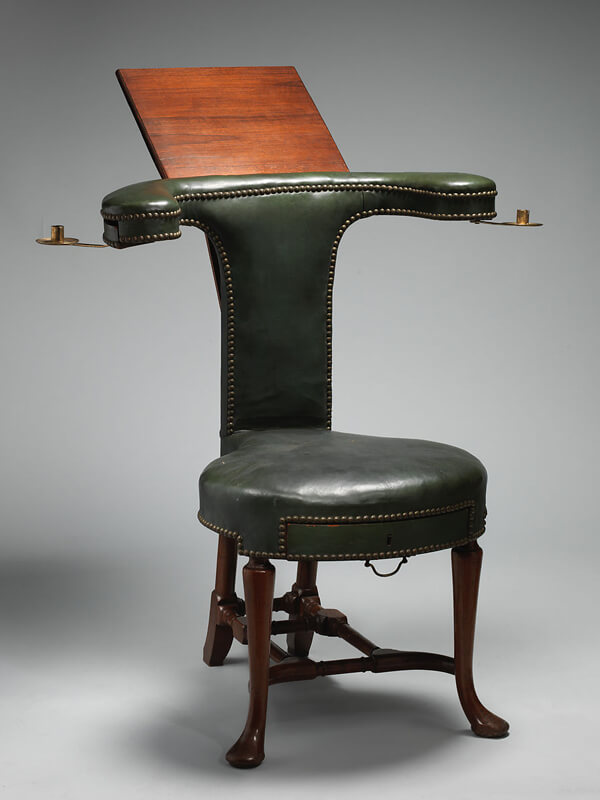 A wooden chair with an extenable desktop